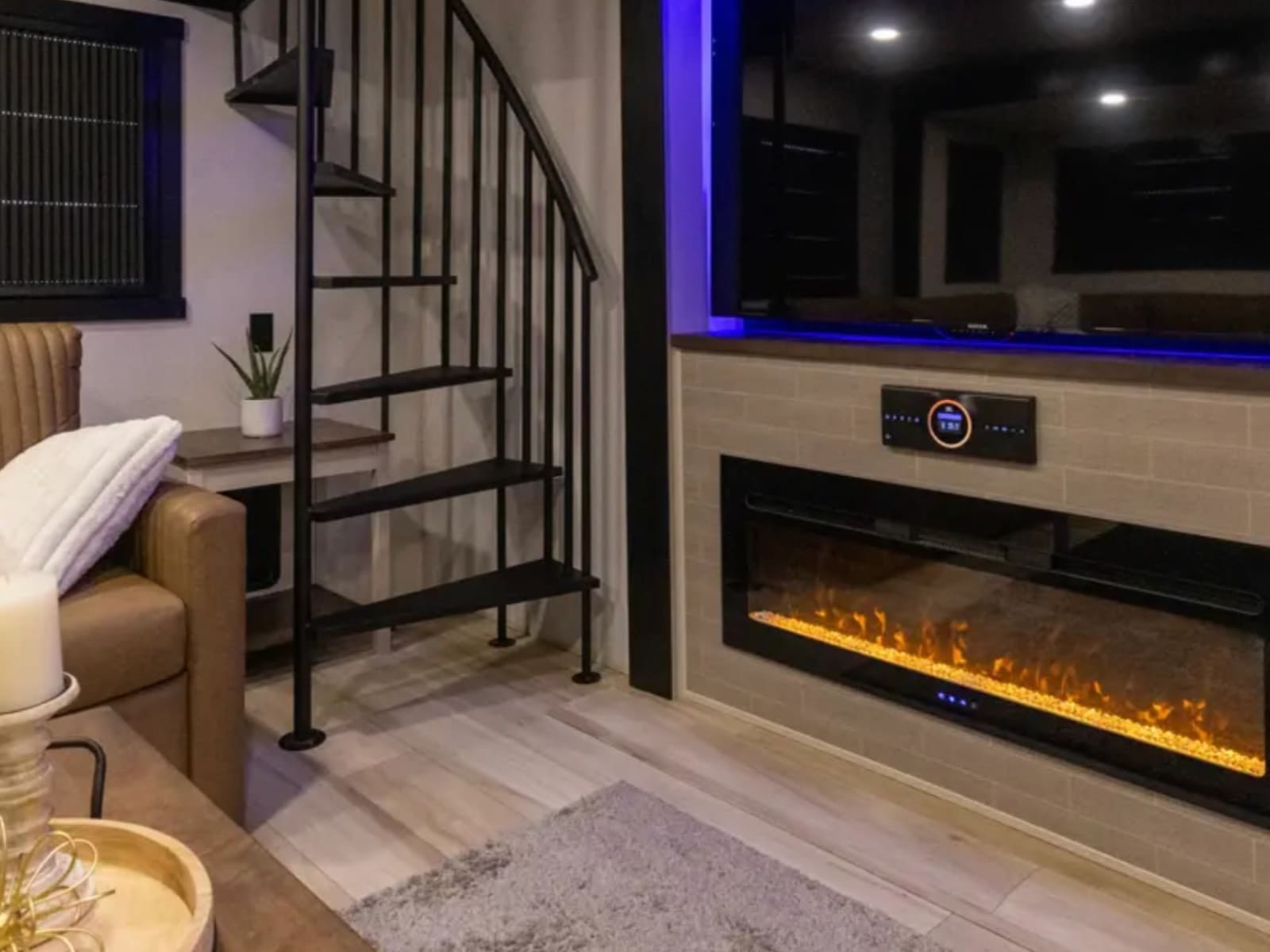 Living area of the Roost43 with electric fireplace and staircase